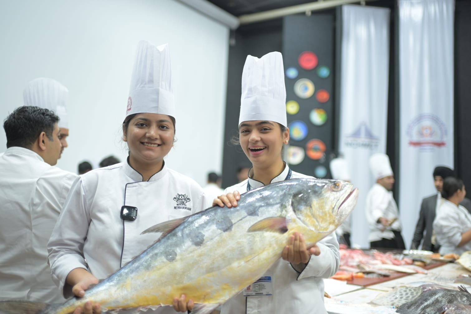 Two hospitality students holding a large fish at the IHM Bhopal seafood workshop
